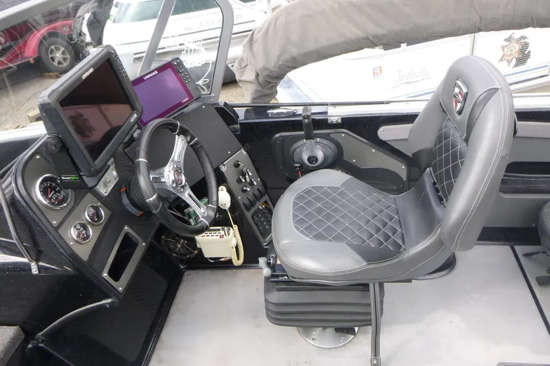 Slide: The Image of 2019 Triton 206 Allure boat cockpit with steering wheel, control panel, and cushioned seat. - 14