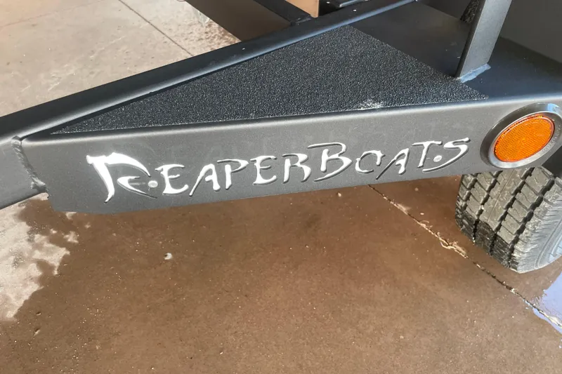 Slide: The Image of Reaper Boats logo on 2026 553 Timber Reaper trailer with orange reflector. - 11