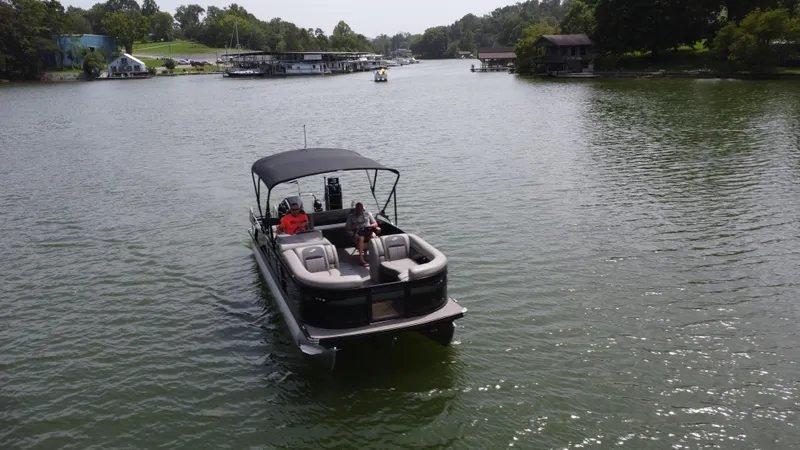 Slide: The Image of 2023 Barletta Corsa 23UC pontoon boat cruising on a scenic lake. - 1