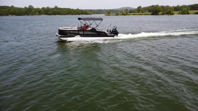 Slide: The Image of 2023 Barletta Corsa 23UC pontoon boat cruising on a scenic lake. - 10