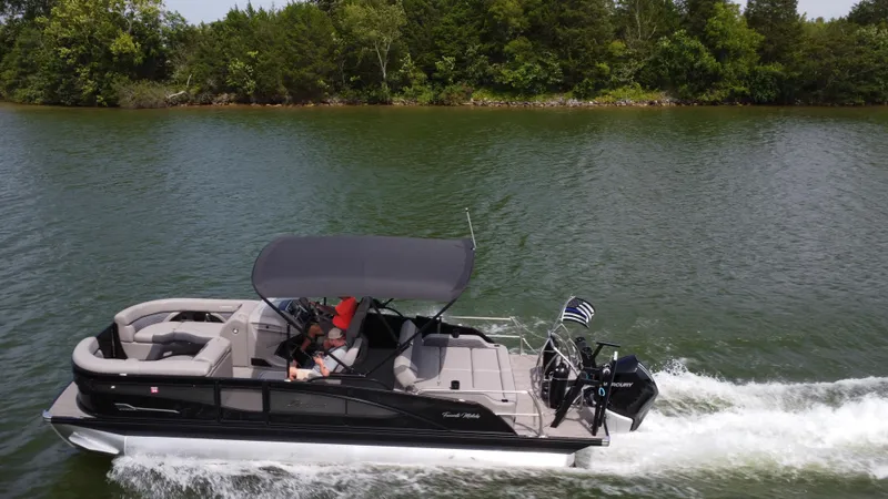 Slide: The Image of 2023 Barletta Corsa 23UC pontoon boat cruising on a scenic lake. - 13
