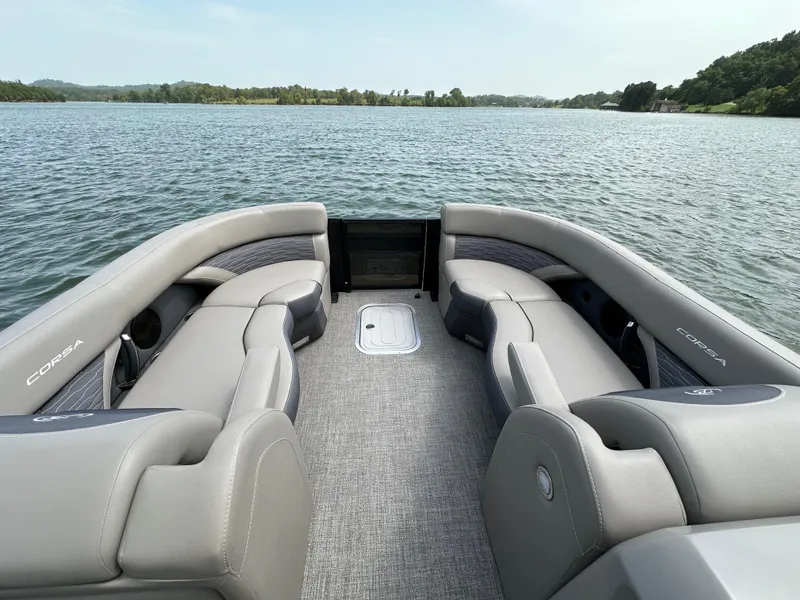 Slide: The Image of 2023 Barletta Corsa 23UC pontoon boat interior with gray seating on a lake. - 16