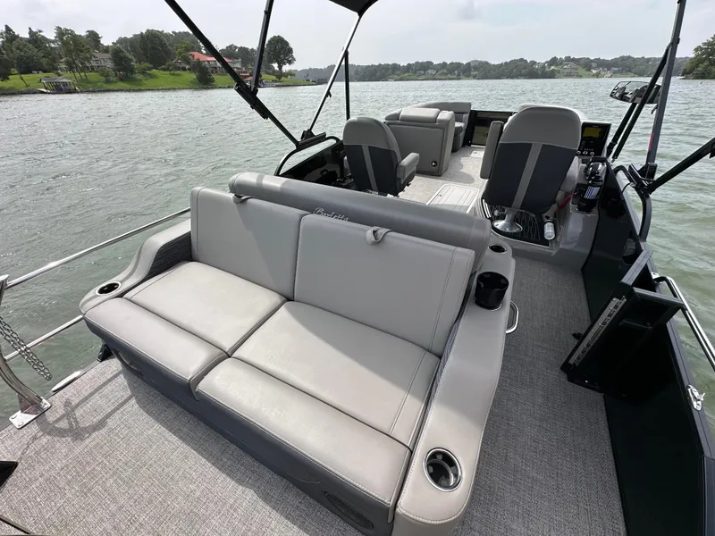 Slide: The Image of 2023 Barletta Corsa 23UC pontoon boat interior with plush seating on a scenic lake. - 21