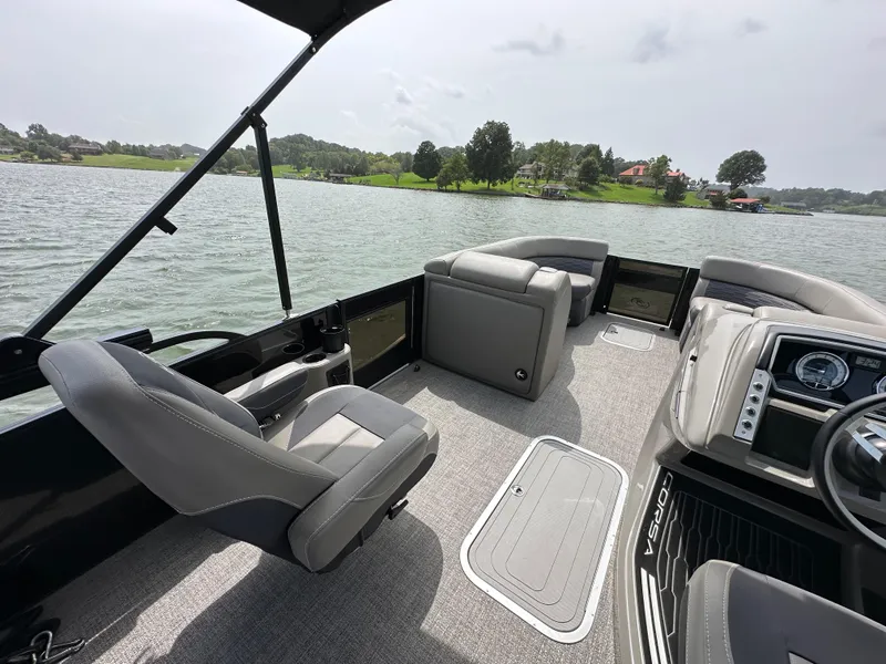 Slide: The Image of 2023 Barletta Corsa 23UC pontoon boat interior with gray seating on a lake. - 23