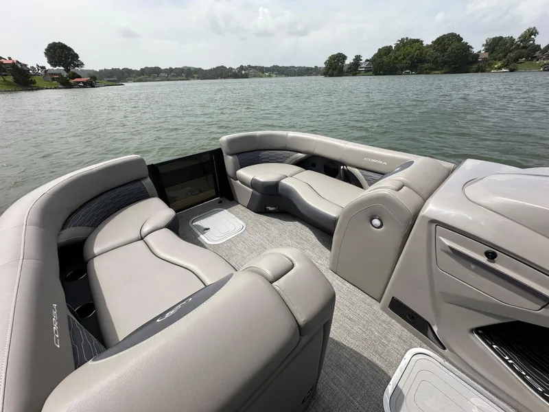 Slide: The Image of 2023 Barletta Corsa 23UC pontoon boat with luxurious seating on a serene lake. - 27