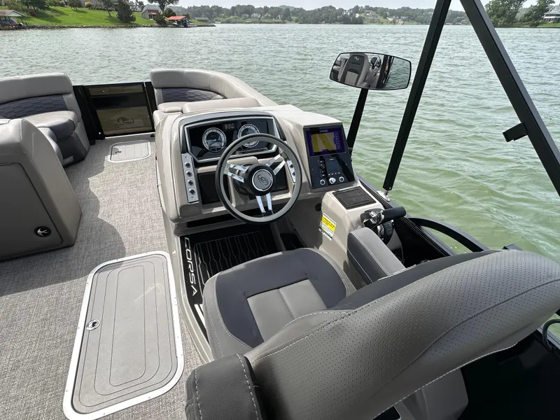 Slide: The Image of 2023 Barletta Corsa 23UC boat interior with steering wheel and dashboard on a lake. - 29
