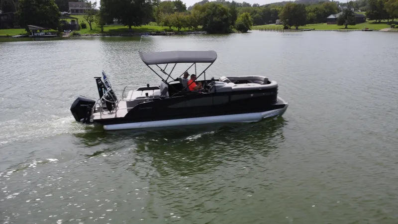 Slide: The Image of 2023 Barletta Corsa 23UC pontoon boat cruising on a serene lake. - 3