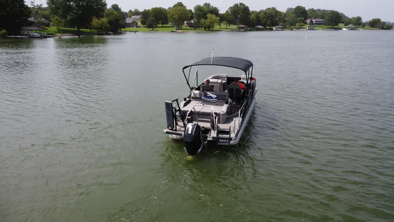 Slide: The Image of 2023 Barletta Corsa 23UC pontoon boat cruising on a serene lake. - 6