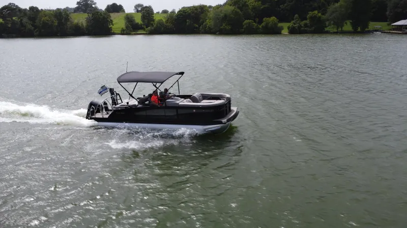 Slide: The Image of 2023 Barletta Corsa 23UC pontoon boat cruising on a scenic lake. - 8