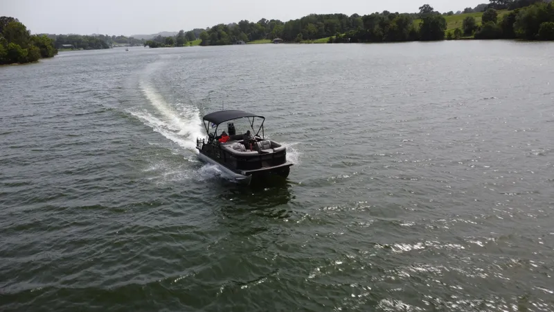 Slide: The Image of 2023 Barletta Corsa 23UC pontoon boat cruising on a scenic lake. - 9