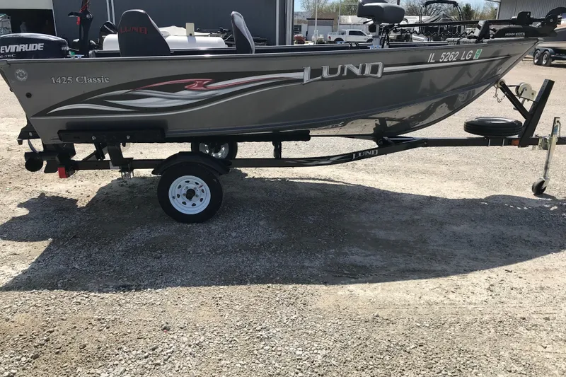 The Image of 2007 Lund 1425 Classic Tiller boat on trailer, side view, parked on gravel. - 1