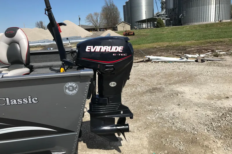 Slide: The Image of 2007 Lund 1425 Classic Tiller boat with Evinrude E-TEC outboard motor on gravel surface. - 12
