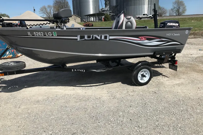 Slide: The Image of 2007 Lund 1425 Classic Tiller boat on trailer, parked outdoors. - 2