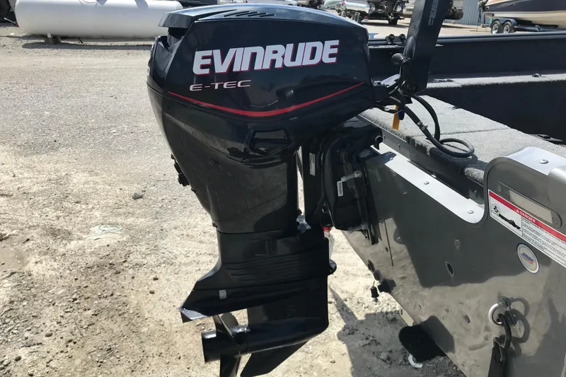 Slide: The Image of 2007 Lund 1425 Classic Tiller with Evinrude E-TEC outboard motor, parked on gravel. - 9