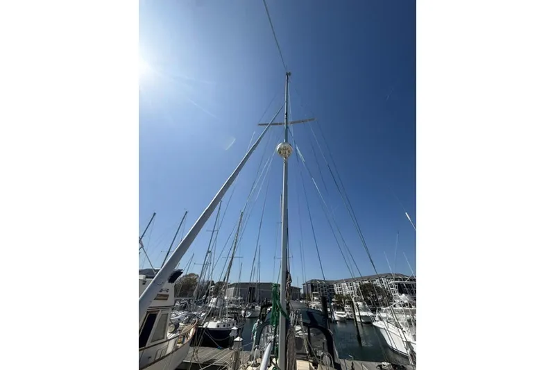Slide: The Image of Sailboat mast of 2001 Island Packet 380 under clear blue sky at marina. - 12