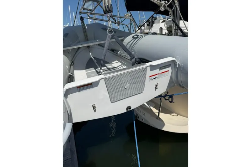 Slide: The Image of 2001 Island Packet 380 sailboat stern view with dinghy and marina background. - 21