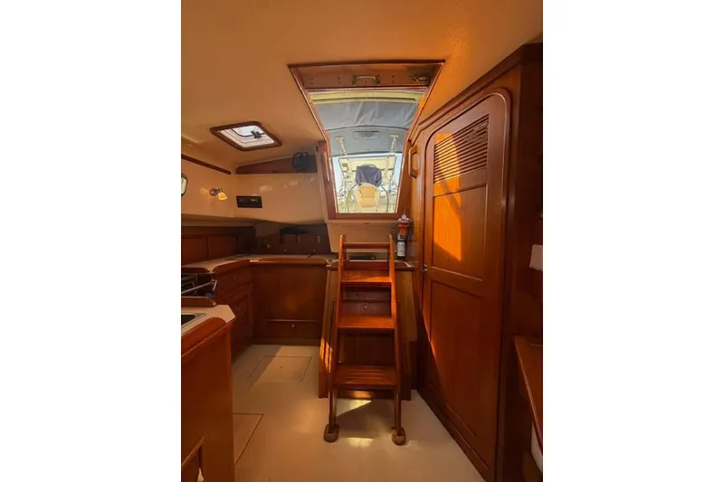 Slide: The Image of Interior of 2001 Island Packet 380 sailboat with wooden cabinetry and stairs. - 24