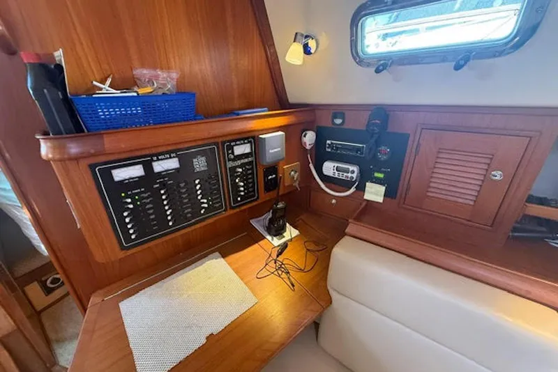 Slide: The Image of Interior view of a 2001 Island Packet 380 sailboat's navigation station with control panels. - 26