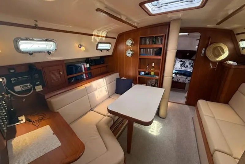 Slide: The Image of Interior of 2001 Island Packet 380 sailboat with cozy seating and wooden accents. - 28