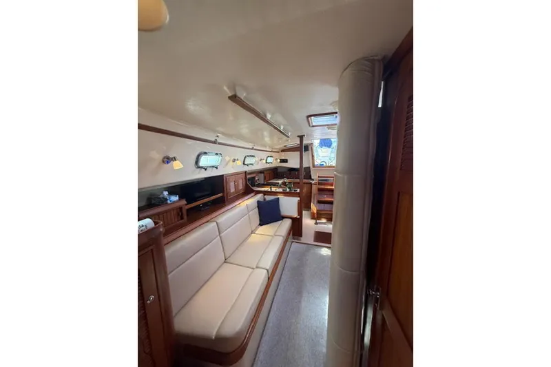 Slide: The Image of Interior of 2001 Island Packet 380 sailboat, featuring cozy seating and wooden cabinetry. - 31