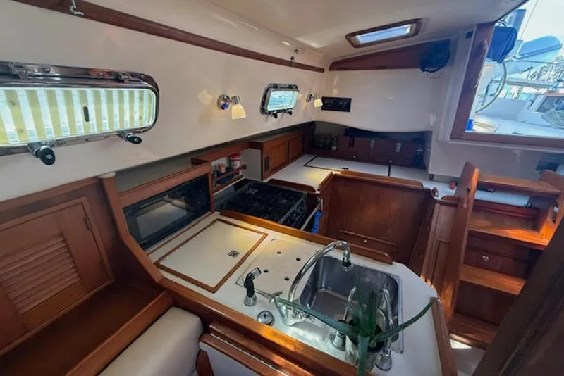 Slide: The Image of Interior of 2001 Island Packet 380 sailboat, featuring a well-equipped kitchen area. - 32