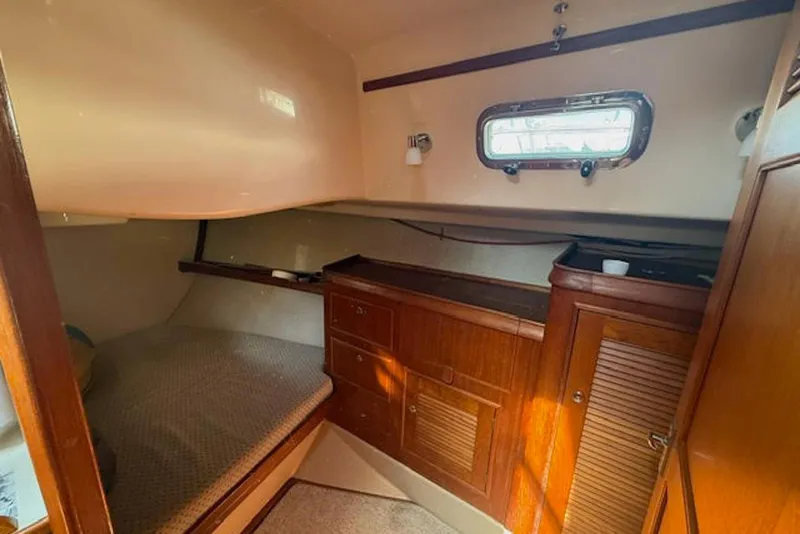 Slide: The Image of Cozy cabin interior of 2001 Island Packet 380 sailboat with wooden cabinetry and porthole. - 34
