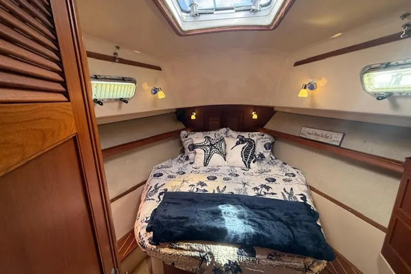 Slide: The Image of Cozy cabin interior of 2001 Island Packet 380 sailboat with nautical-themed bedding. - 35