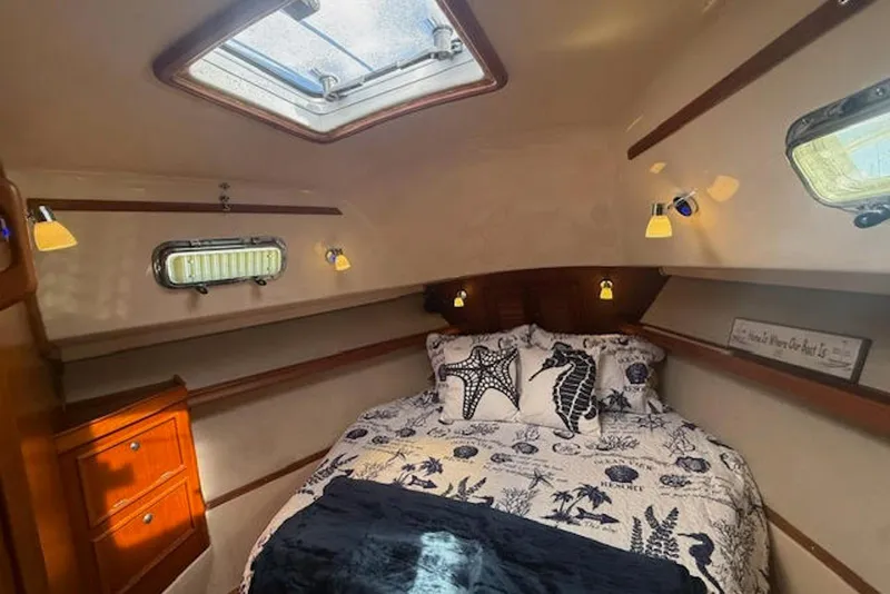 Slide: The Image of Cozy cabin interior of 2001 Island Packet 380 sailboat with nautical-themed bedding. - 36