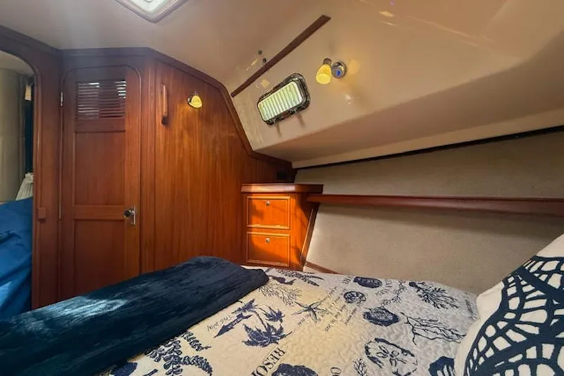 Slide: The Image of Cozy cabin interior of 2001 Island Packet 380 sailboat with wooden accents and nautical bedding. - 37