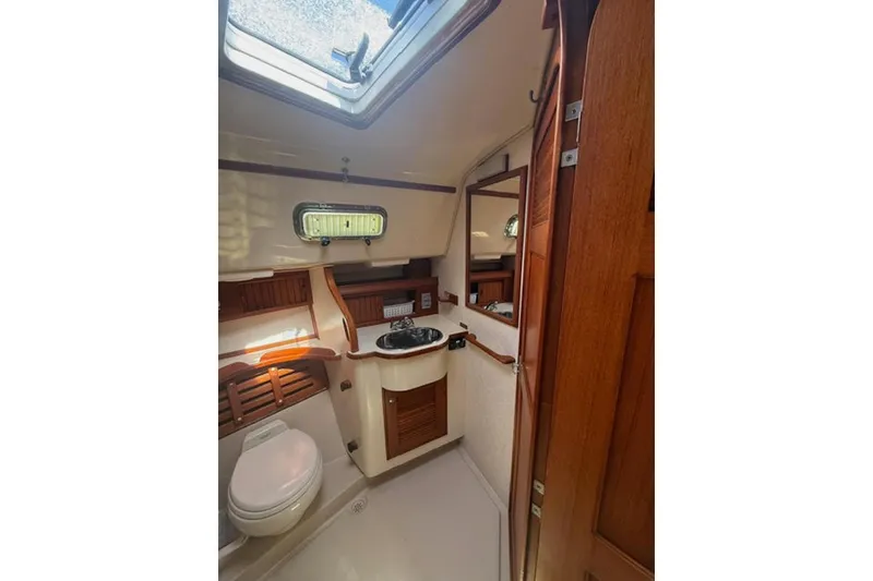 Slide: The Image of Interior of 2001 Island Packet 380 sailboat bathroom with wooden cabinetry and skylight. - 40