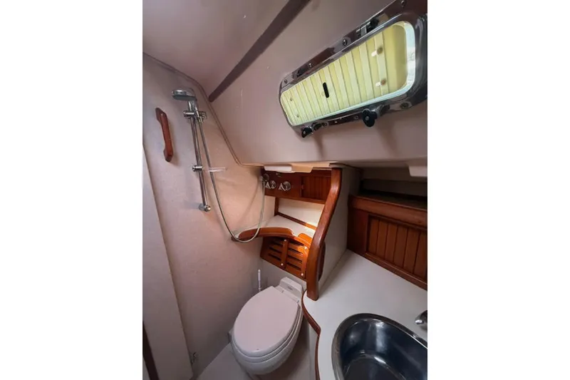Slide: The Image of 2001 Island Packet 380 yacht bathroom with shower, toilet, and porthole window. - 41