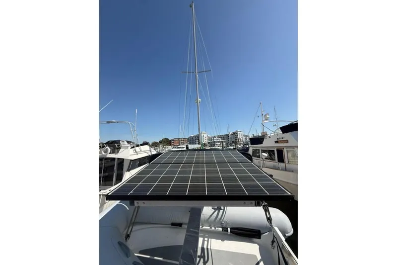 Slide: The Image of Island Packet 380 sailboat (2001) with solar panel, docked in marina under clear blue sky. - 49