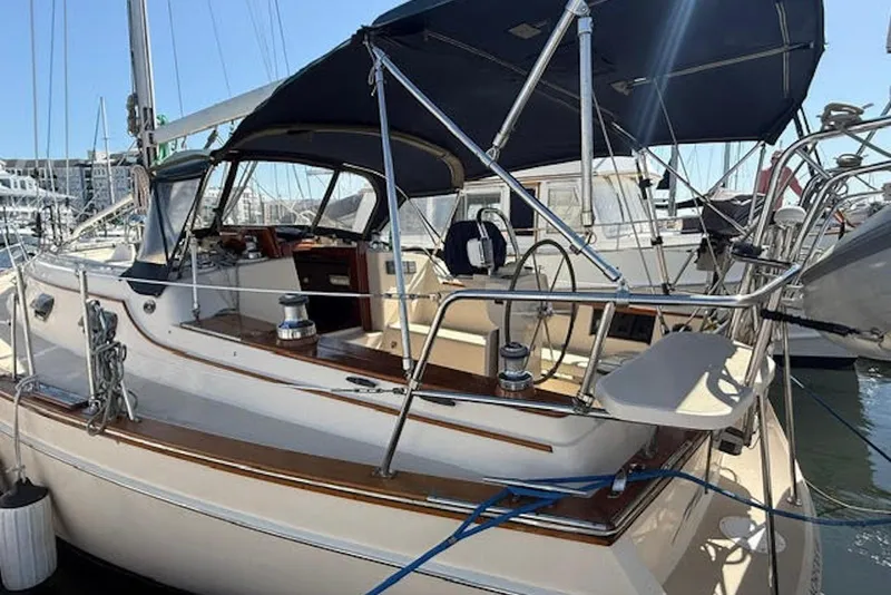 Slide: The Image of 2001 Island Packet 380 sailboat docked at marina, featuring spacious cockpit and canopy. - 6