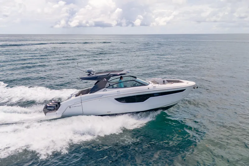 Slide: The Image of 2021 Cruisers Yachts 38 GLS speeding on open water under a cloudy sky. - 15