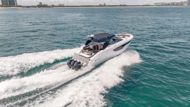 Slide: The Image of 2021 Cruisers Yachts 38 GLS speeding on open water, showcasing sleek design and powerful engines. - 17