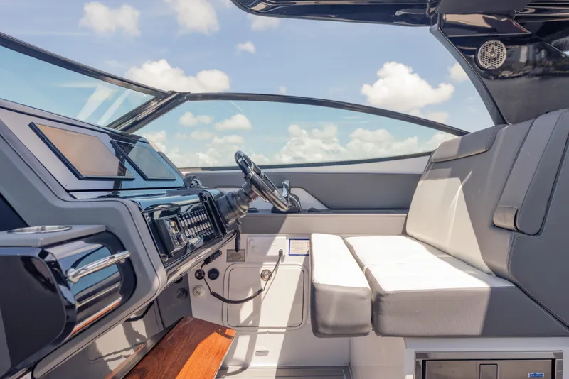 Slide: The Image of Interior of 2021 Cruisers Yachts 38 GLS, featuring sleek dashboard and comfortable seating. - 32