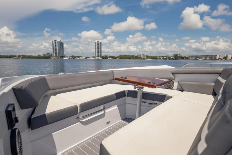 Slide: The Image of Luxurious seating area on 2021 Cruisers Yachts 38 GLS, overlooking serene waterfront skyline. - 44