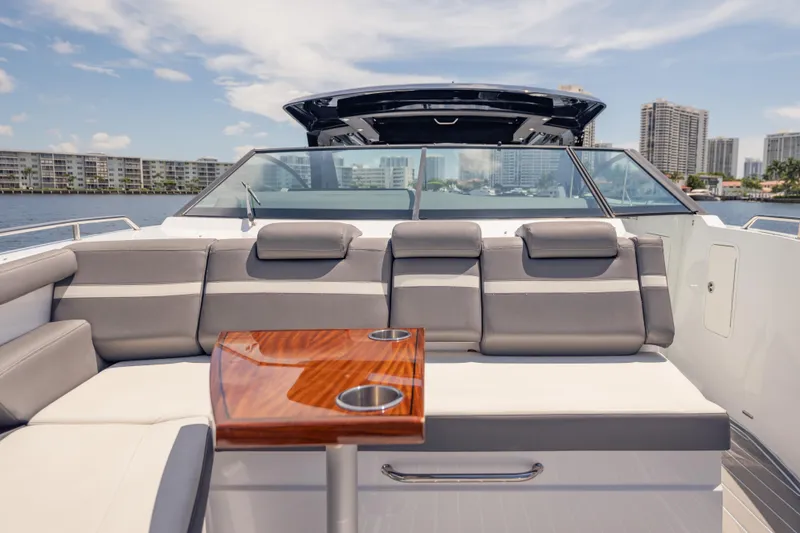 Slide: The Image of 2021 Cruisers Yachts 38 GLS luxury boat interior with seating and table, cityscape in background. - 46