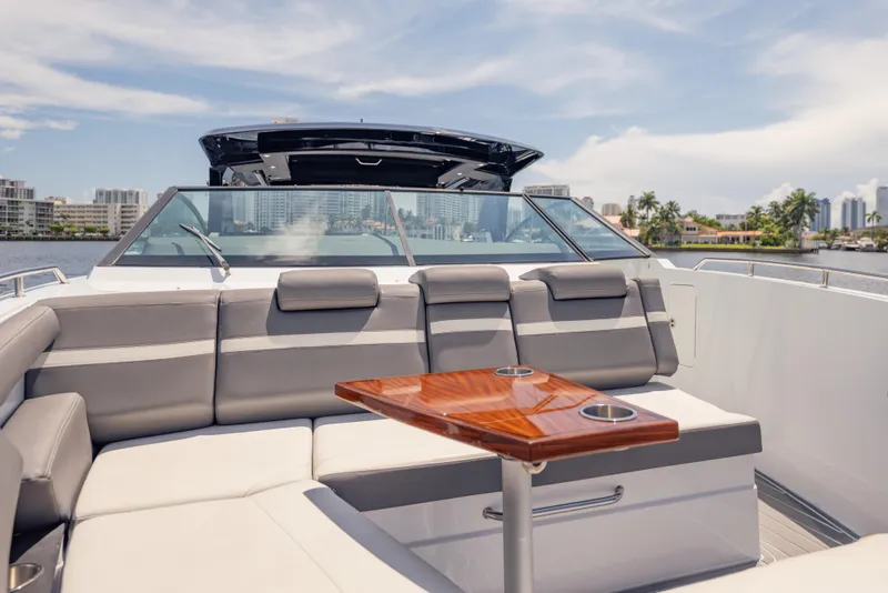 Slide: The Image of 2021 Cruisers Yachts 38 GLS interior with luxurious seating and wooden table, cityscape in background. - 47