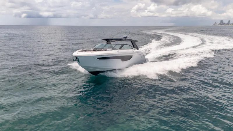 Slide: The Image of 2021 Cruisers Yachts 38 GLS speeding on open water under cloudy skies. - 8