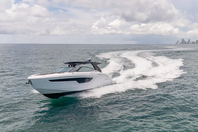 Slide: The Image of 2021 Cruisers Yachts 38 GLS speeding on open water under cloudy skies. - 9