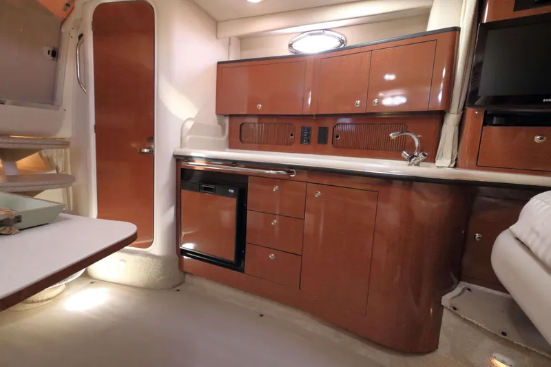 Slide: The Image of 2004 Sea Ray Sundancer 320 interior with wood cabinetry and modern amenities. - 17