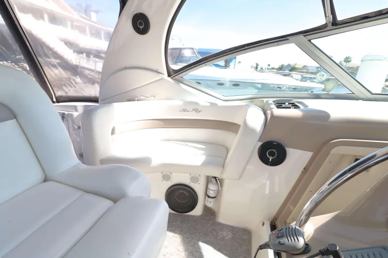 Slide: The Image of Interior of a 2004 Sea Ray Sundancer 320 boat, featuring white seating and helm controls. - 6