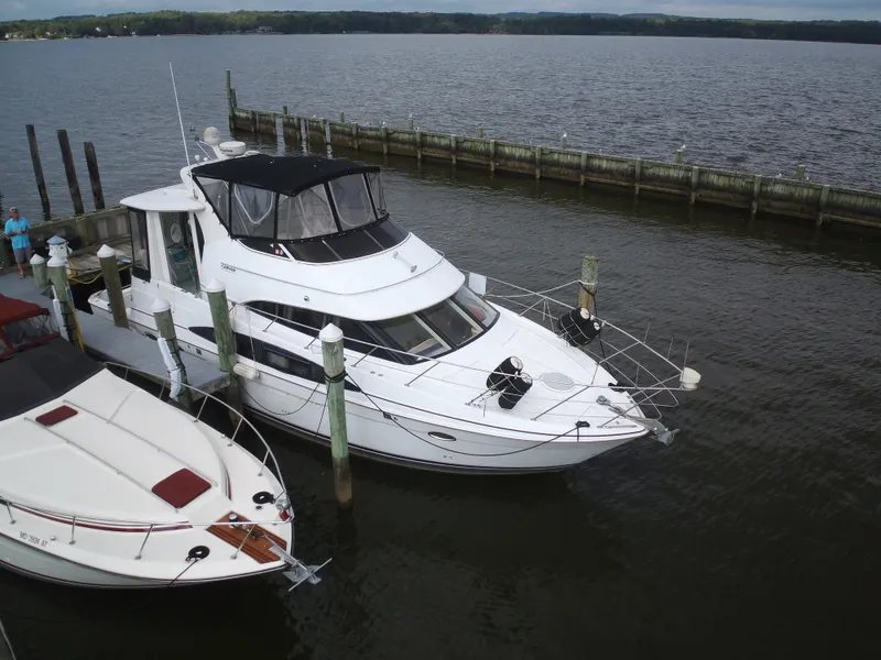 Slide: The Image of A 2003 Carver 44 Cockpit Motor Yacht docked. It features a white deck and black canopy. - 4
