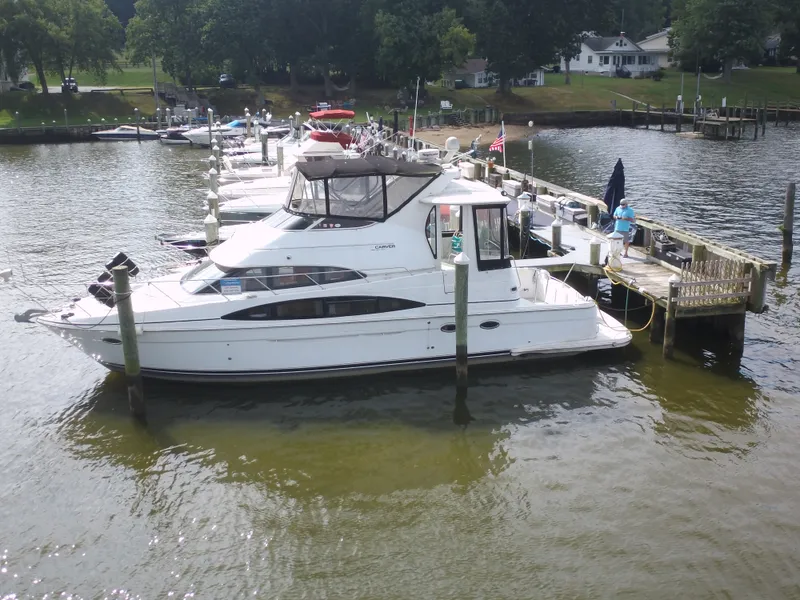 Slide: The Image of A 2003 Carver 44 Cockpit Motor Yacht docked at a peaceful marina. - 1