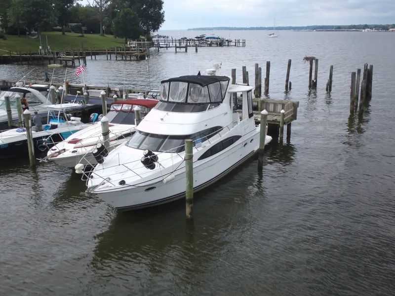 Slide: The Image of A 2003 Carver 44 Cockpit Motor Yacht docked in a calm harbor. - 2