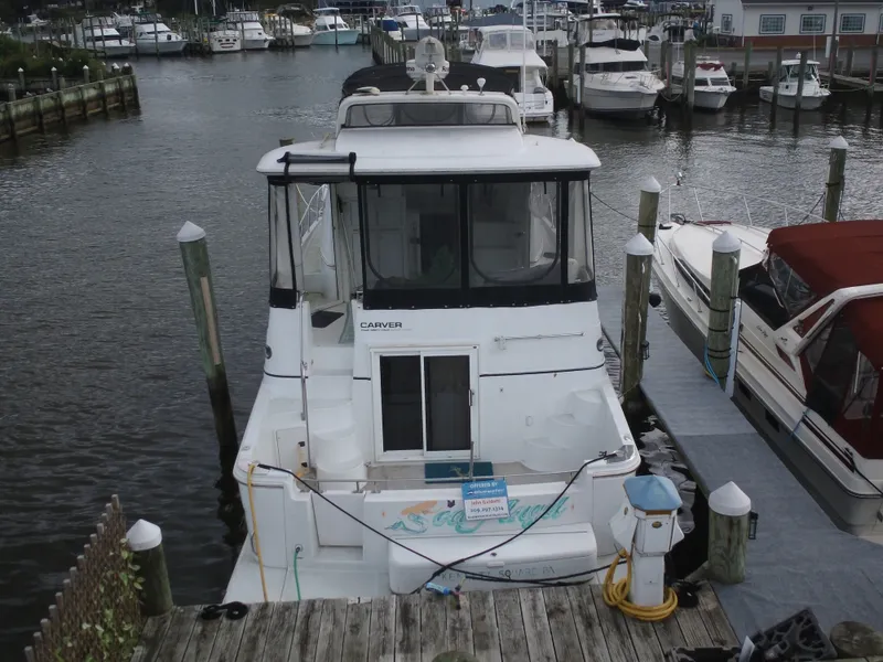 Slide: The Image of 2003 Carver 44 Cockpit Motor Yacht docked, surrounded by other boats. - 5