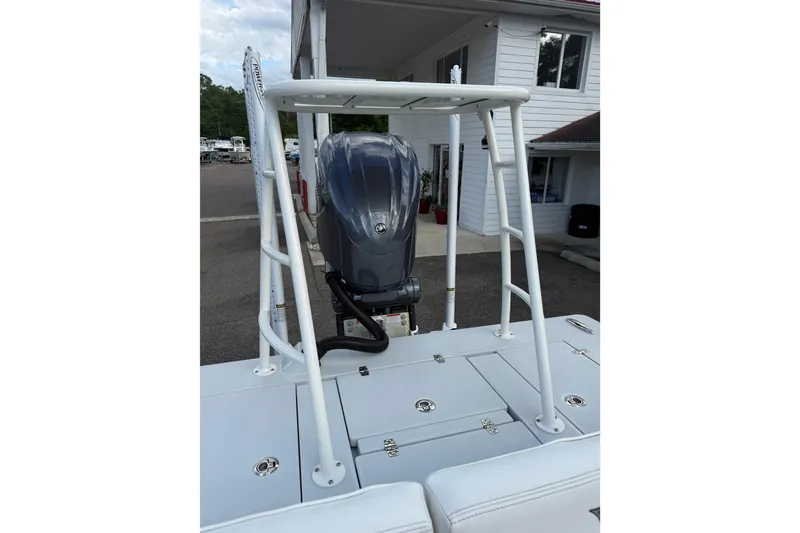 Slide: The Image of 2023 Hewes Redfisher 21 boat with outboard motor, docked near a building. - 13