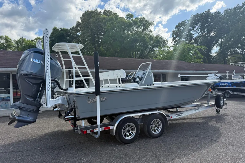 Slide: The Image of 2023 Hewes Redfisher 21 boat with Yamaha engine on a trailer, parked outdoors. - 5