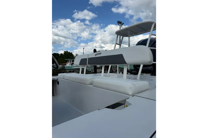 Slide: The Image of 2023 Hewes Redfisher 21 boat with sleek seating under a partly cloudy sky. - 9